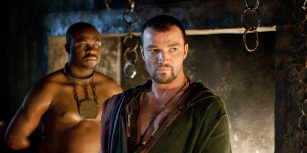 Ashur looking off into the distance with a servant standing behind him in Spartacus